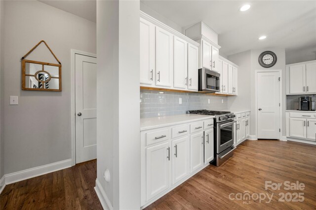 3588 County Down Ave, Kannapolis, NC 28081 - kitchen with appliances with stainless steel finishes, light countertops, backsplash, white cabinets, and dark wood-type flooring