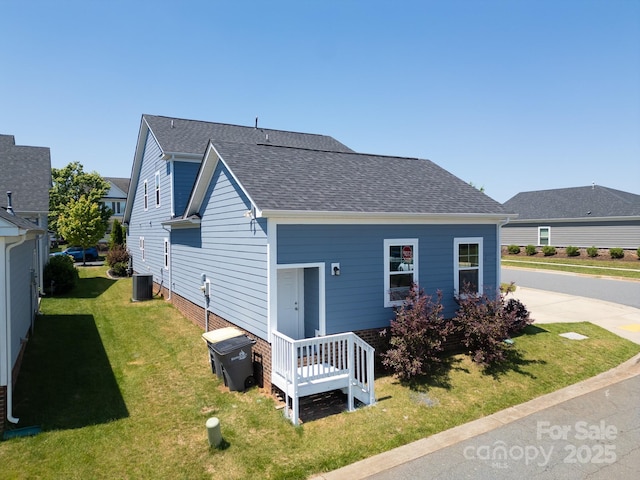 3588 County Down Ave, Kannapolis, NC 28081 - view of front of house with cooling unit, roof with shingles, and a front yard
