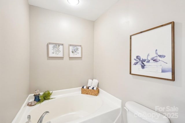 bathroom with a garden tub and toilet