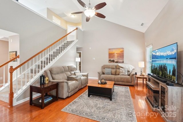 3032 Kilbeggan Dr, Clover, SC 29710 - living area with high vaulted ceiling, a ceiling fan, stairway, light wood-style flooring, and a fireplace