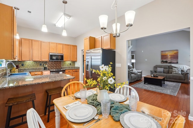 3032 Kilbeggan Dr, Clover, SC 29710 - kitchen with a sink, appliances with stainless steel finishes, a peninsula, wood finished floors, and backsplash