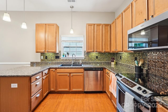 3032 Kilbeggan Dr, Clover, SC 29710 - kitchen featuring stainless steel appliances, a sink, a peninsula, light wood-type flooring, and backsplash