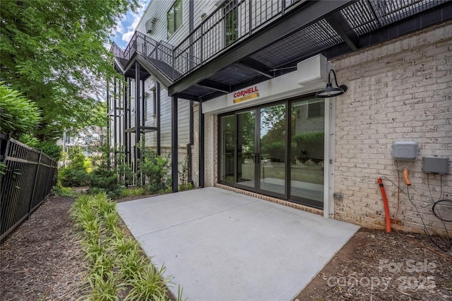614 Queens Rd, Charlotte, NC 28207 - property entrance featuring a balcony, fence, a patio, and brick siding
