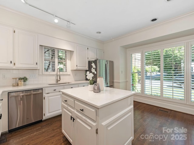232 Perrin Pl, Charlotte, NC 28207 - kitchen featuring appliances with stainless steel finishes, a sink, tasteful backsplash, plenty of natural light, and ornamental molding