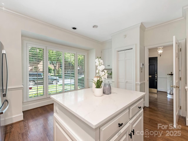 232 Perrin Pl, Charlotte, NC 28207 - kitchen featuring dark wood-type flooring, crown molding, a center island, and white cabinetry