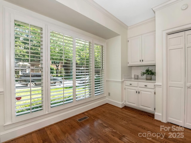 232 Perrin Pl, Charlotte, NC 28207 - unfurnished dining area with crown molding and dark wood finished floors