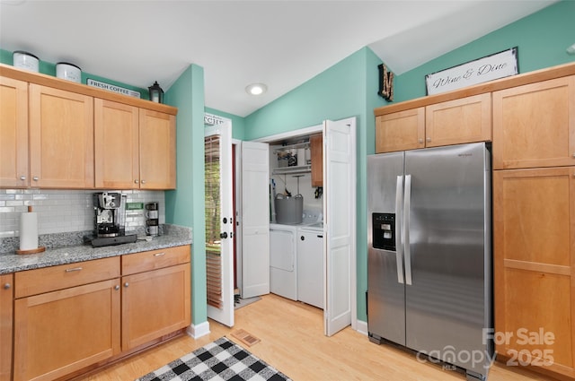 kitchen with independent washer and dryer, tasteful backsplash, stainless steel fridge with ice dispenser, lofted ceiling, and light wood-style flooring
