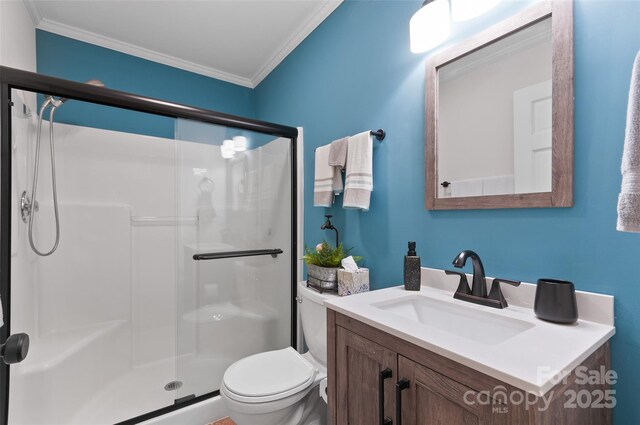 bathroom featuring vanity, ornamental molding, a stall shower, and toilet