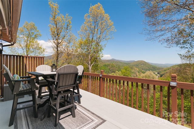 deck with a mountain view and outdoor dining space