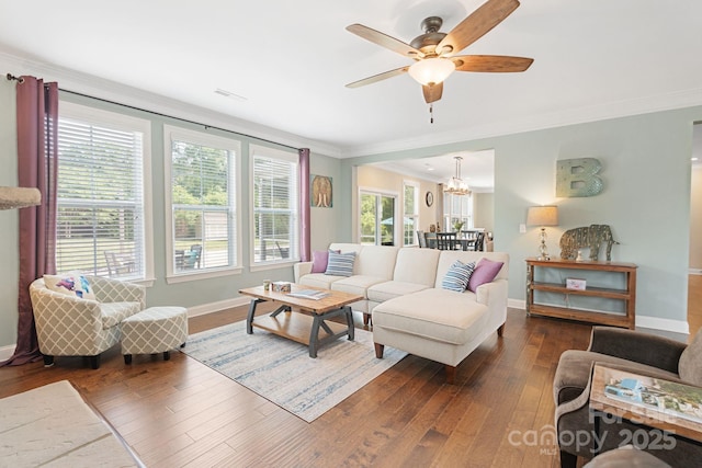 living room featuring wood-type flooring, baseboards, ornamental molding, and ceiling fan with notable chandelier