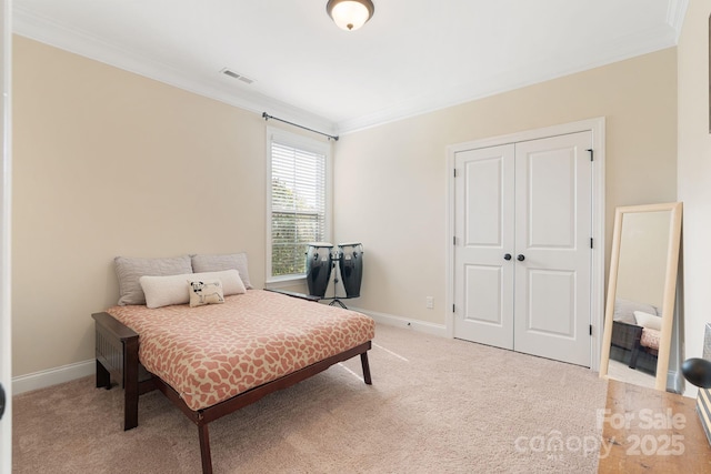 bedroom with baseboards, ornamental molding, a closet, and visible vents