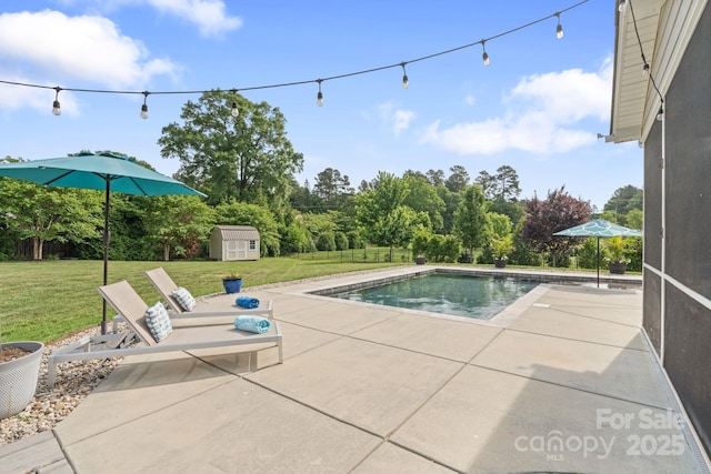 pool featuring a lawn, a patio area, and a shed