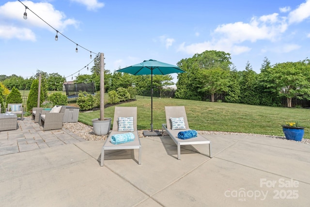 view of patio / terrace with fence, a trampoline, and an outdoor hangout area