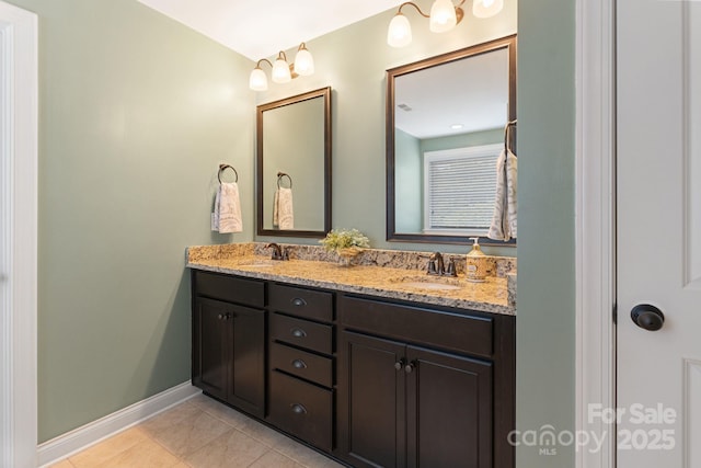 full bathroom with a sink, baseboards, and double vanity