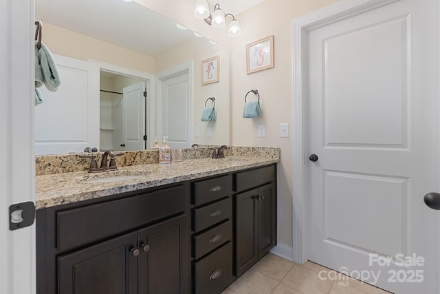 bathroom with double vanity, a sink, and tile patterned floors