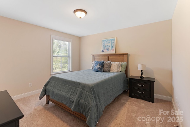 bedroom with baseboards and light colored carpet