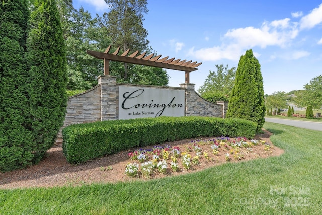 community sign featuring a yard