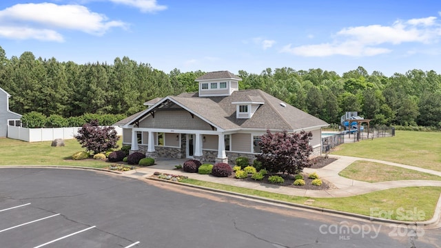 craftsman-style house featuring covered porch, fence, uncovered parking, and stone siding