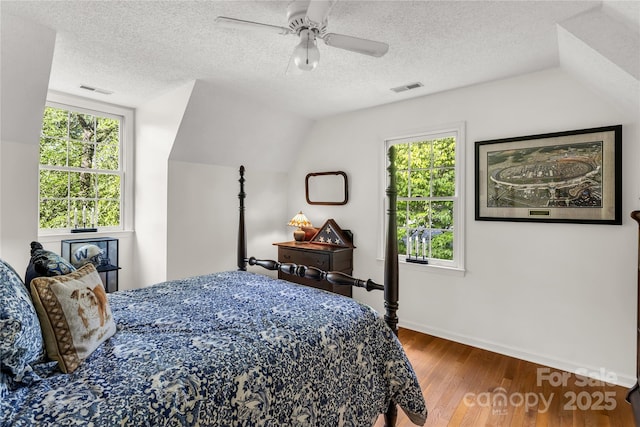 709 Weldon Ln, Salisbury, NC 28146 - bedroom featuring a textured ceiling, baseboards, wood finished floors, vaulted ceiling, and visible vents