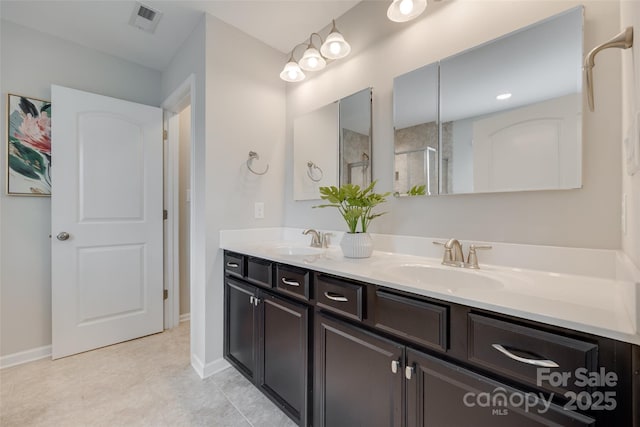 bathroom with an enclosed shower, double vanity, visible vents, and a sink