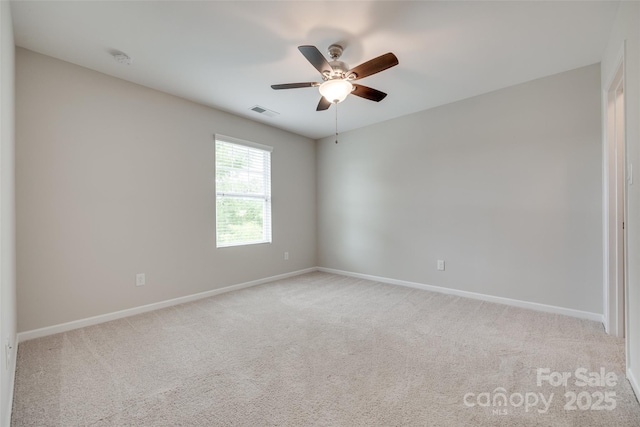 spare room featuring ceiling fan, visible vents, light carpet, and baseboards