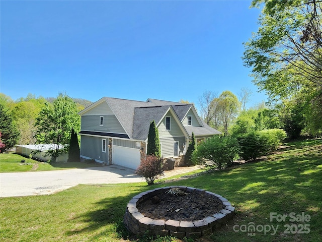 521 Hobson Rd, Bakersville, NC 28705 - view of front of home with concrete driveway, a front lawn, a garage, and a fire pit