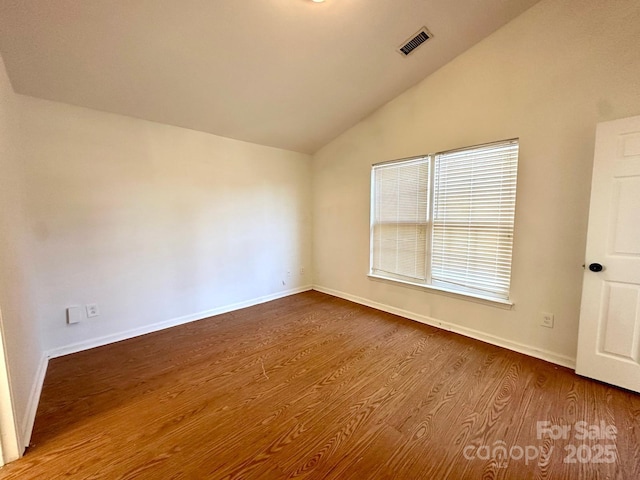 8551 Appledale Dr, Charlotte, NC 28262 - empty room featuring lofted ceiling, baseboards, and dark wood-style floors