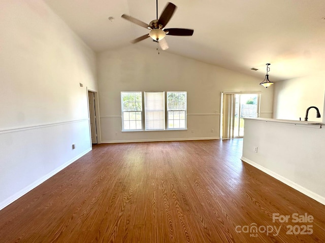 8551 Appledale Dr, Charlotte, NC 28262 - unfurnished living room with high vaulted ceiling, plenty of natural light, a ceiling fan, dark wood finished floors, and baseboards