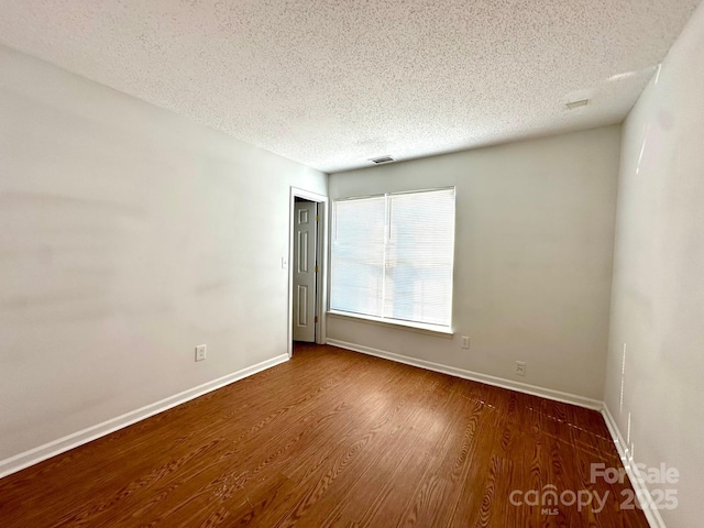 8551 Appledale Dr, Charlotte, NC 28262 - spare room with a textured ceiling, wood finished floors, and baseboards