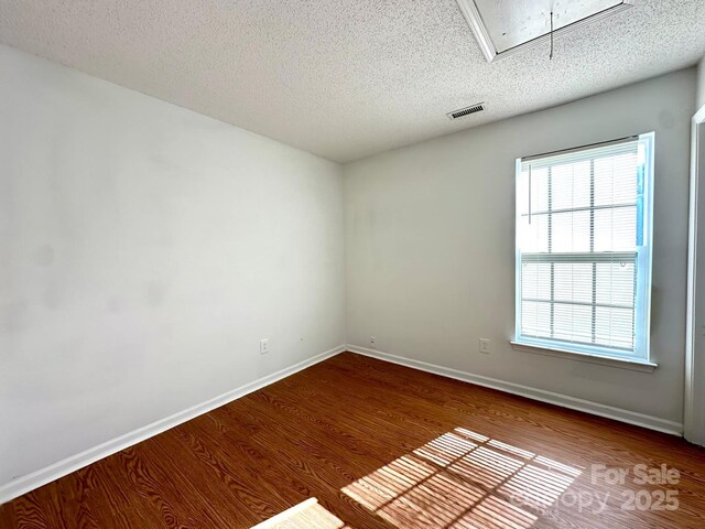 8551 Appledale Dr, Charlotte, NC 28262 - spare room with attic access, wood finished floors, a textured ceiling, and baseboards