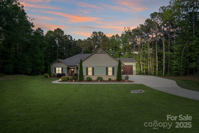view of front of home featuring concrete driveway, a garage, a front yard, and board and batten siding