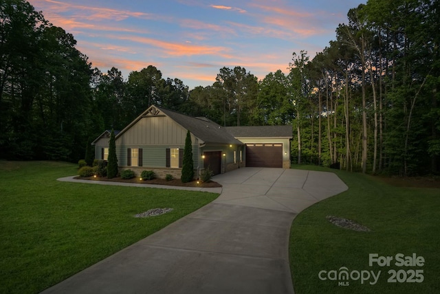 view of front of property featuring concrete driveway, board and batten siding, an attached garage, a front lawn, and brick siding