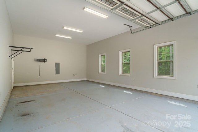 garage featuring baseboards and electric panel