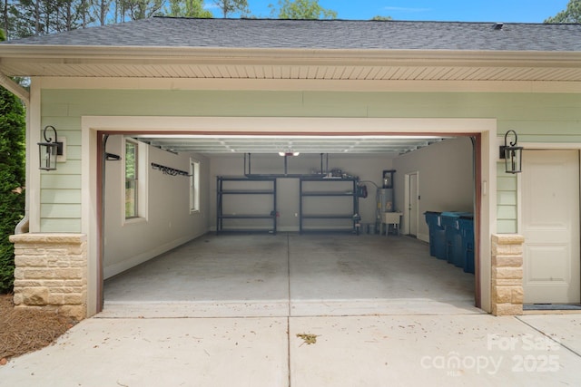 garage featuring secured water heater and concrete driveway