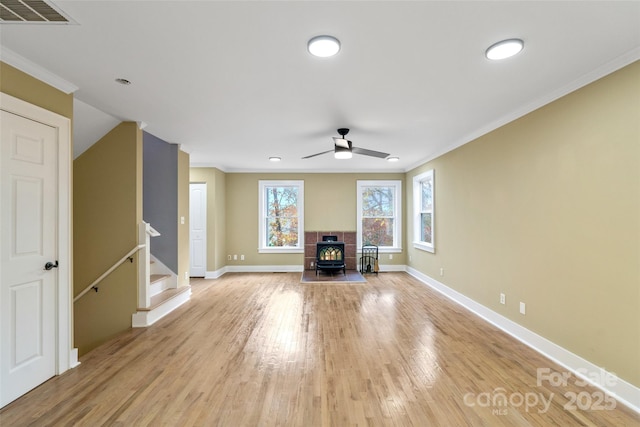 living room with crown molding, visible vents, ceiling fan, baseboards, and light wood finished floors