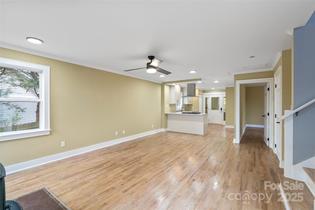 unfurnished living room with crown molding, light wood finished floors, ceiling fan, and baseboards