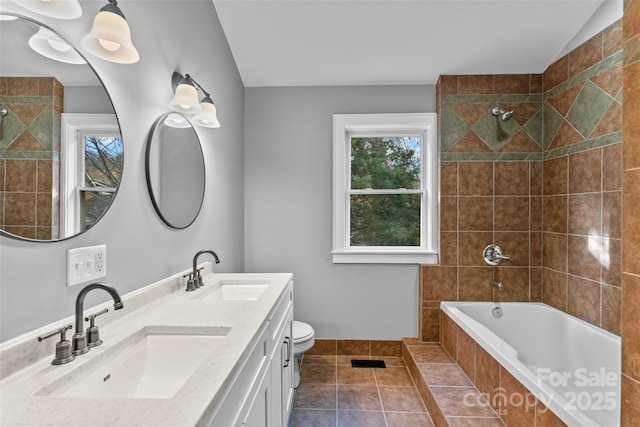 full bath with double vanity, tiled shower / bath combo, tile patterned flooring, and a sink