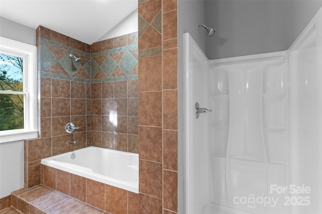full bath featuring tiled shower / bath combo and vaulted ceiling
