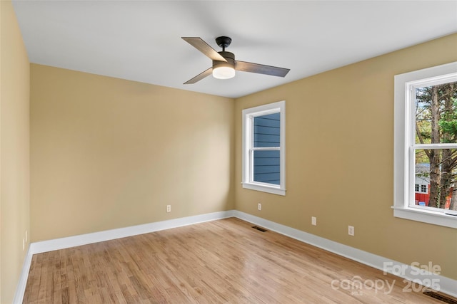 empty room featuring baseboards, visible vents, ceiling fan, and light wood-style flooring