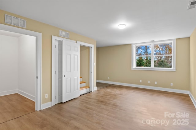 unfurnished bedroom featuring visible vents, wood finished floors, and baseboards