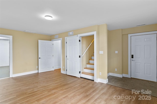 interior space with wood finished floors, visible vents, and baseboards