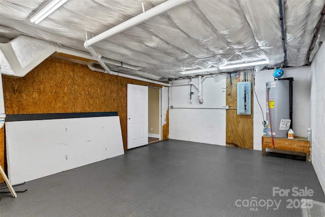garage with water heater, concrete block wall, and electric panel