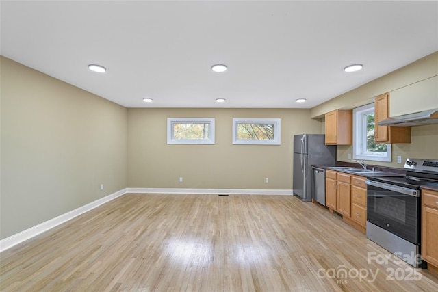 kitchen featuring stainless steel appliances, a wealth of natural light, under cabinet range hood, and a sink