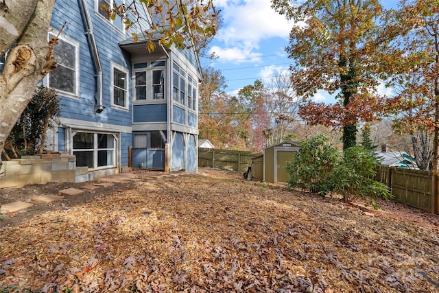 back of property featuring an outdoor structure, a storage shed, and a fenced backyard
