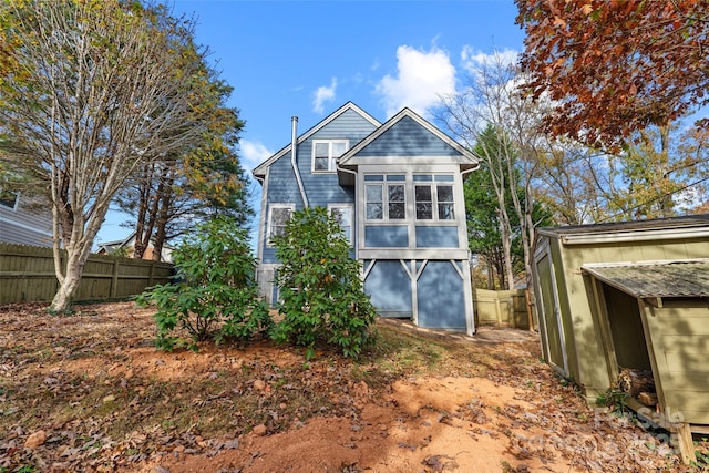 rear view of house featuring fence
