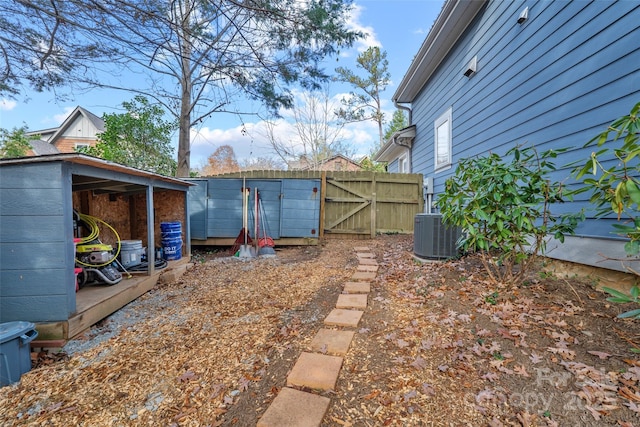 view of yard featuring fence, a gate, and central AC unit