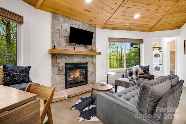 16 Caddis Ct, Marshall, NC 28753 - living room with stacked washing machine and dryer, wooden ceiling, healthy amount of natural light, a stone fireplace, and concrete floors