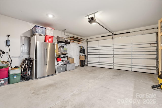 104 Trellis Ln, Troutman, NC 28166 - garage with freestanding refrigerator, electric panel, and a garage door opener