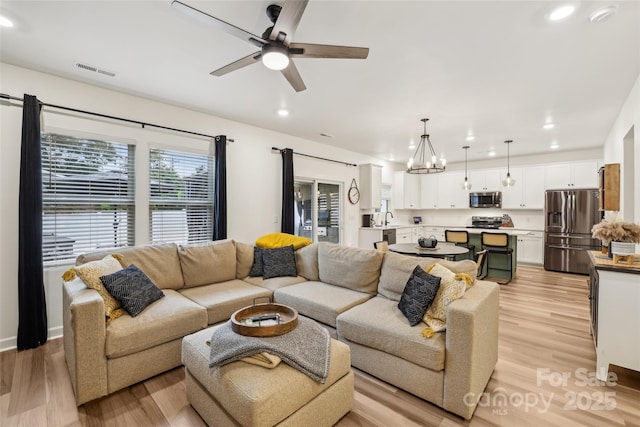 104 Trellis Ln, Troutman, NC 28166 - living area with light wood-type flooring, recessed lighting, ceiling fan, and a chandelier
