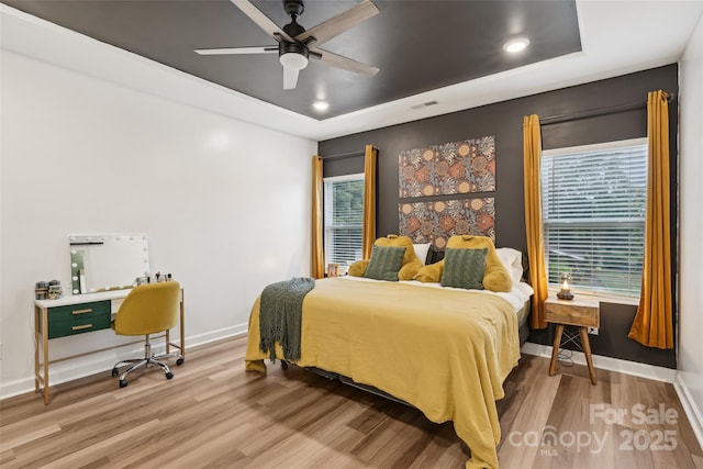 104 Trellis Ln, Troutman, NC 28166 - bedroom featuring a tray ceiling, light wood finished floors, multiple windows, and recessed lighting